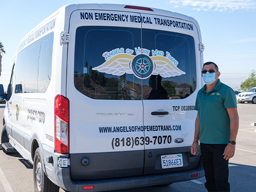 Armando Miranda, owner of Angels of Hope Med Trans, beside his non-emergency medical transport van
