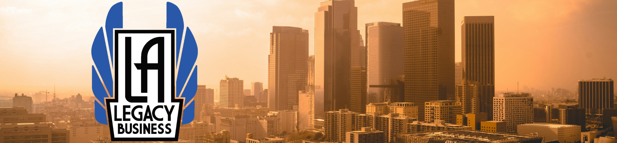 L.A. Legacy Business logo (program name in a white art deco font flanked by art deco style blue wings) over an image of downtown Los Angeles at golden hour sunset